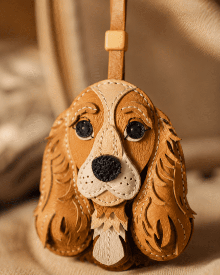 Close-up of handmade cocker spaniel leather bag charm with long caramel ears, cream muzzle, and black nose