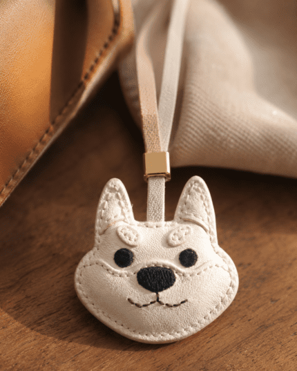 White leather dog face charm on table with coffee cup, cake, and open book, cozy sunlight