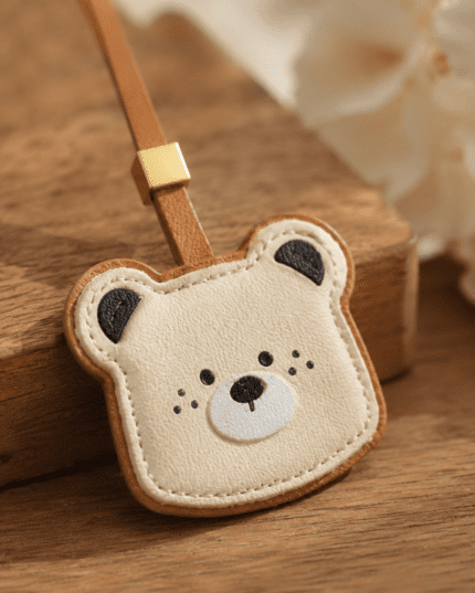 Close-up of handmade leather bear bee charm, details of stitching and soft leather
