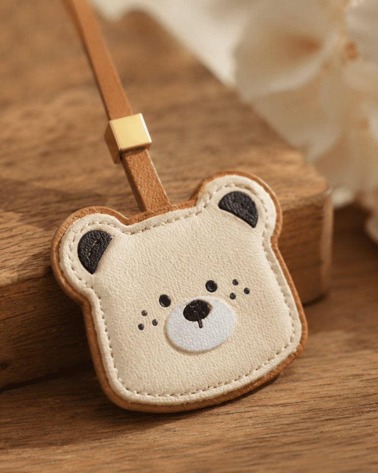 Close-up of handmade leather bear bee charm, details of stitching and soft leather
